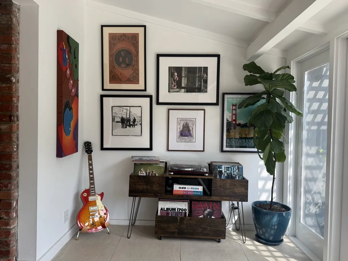 Music wall with guitar, vinyl records, and framed prints